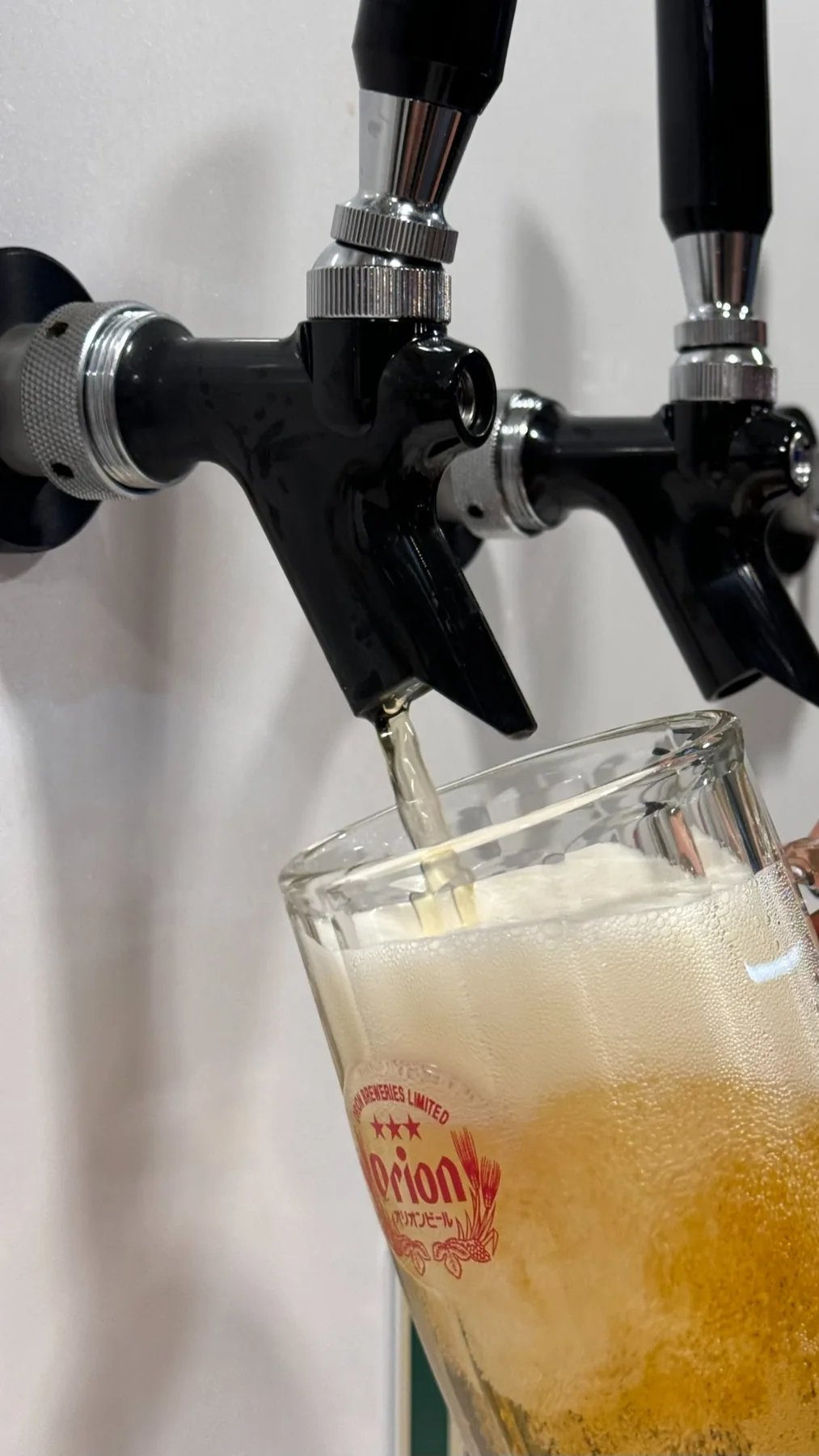 タップからグラスに注がれるオリオンビール